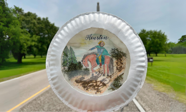A collage on a paper plate held up in front of the San Jacinto Monument.