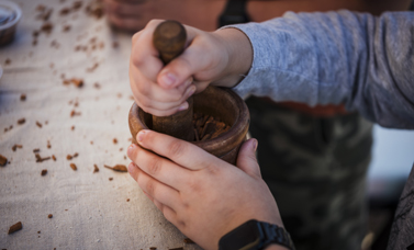 Hands use a mortar and pestle.