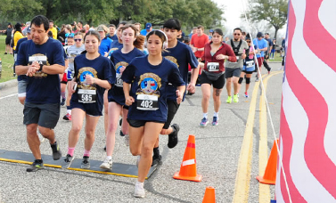 A group of runners pass the starting gate.