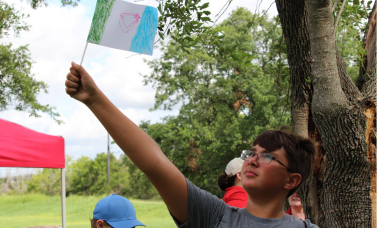 A child's waves a handmade flag above his head.