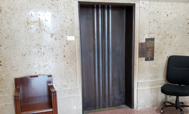 Closed elevator doors set in to a stone wall.