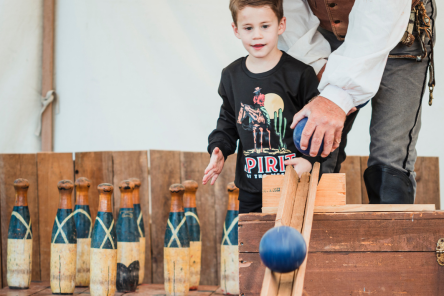 A child enjoys 19th centruy bowling game at the Fall Fandango.